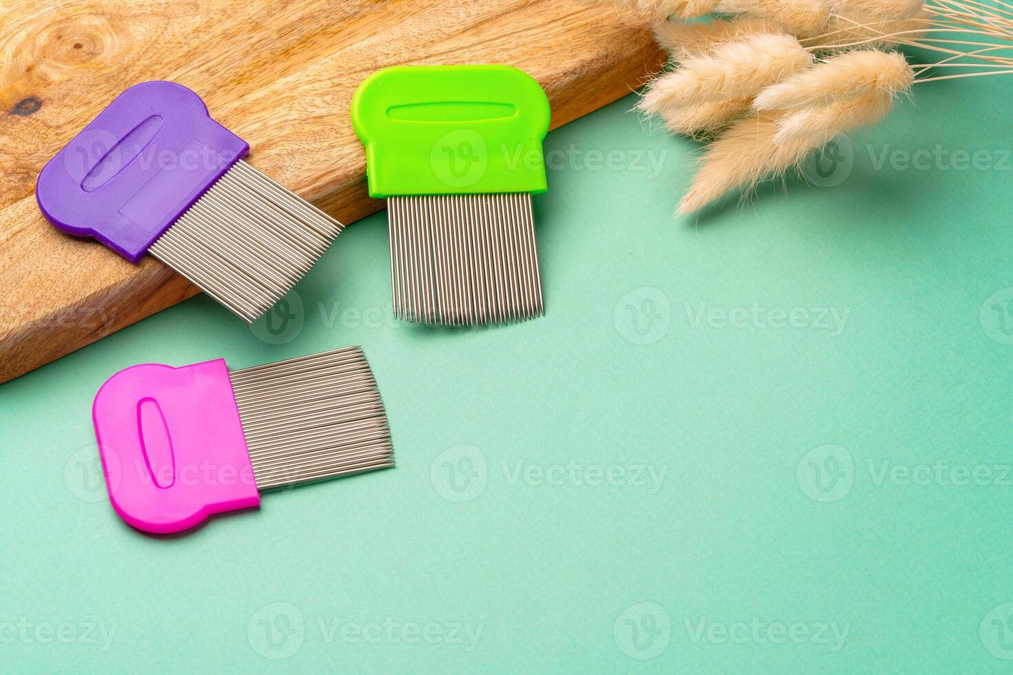 Three combs for lice removing on green background photo