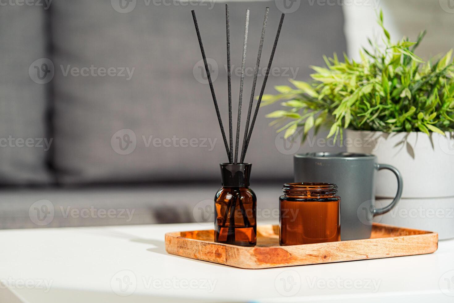 Aromatic reed freshener and candle on table in room photo