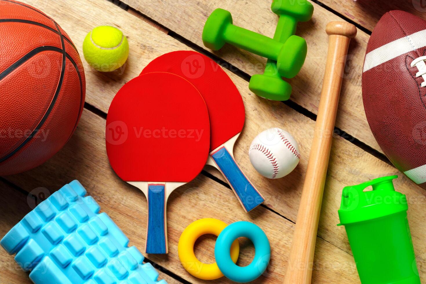 Different sports equipment on wooden background top view photo