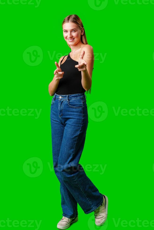 Young Woman Pointing at Something against green background photo