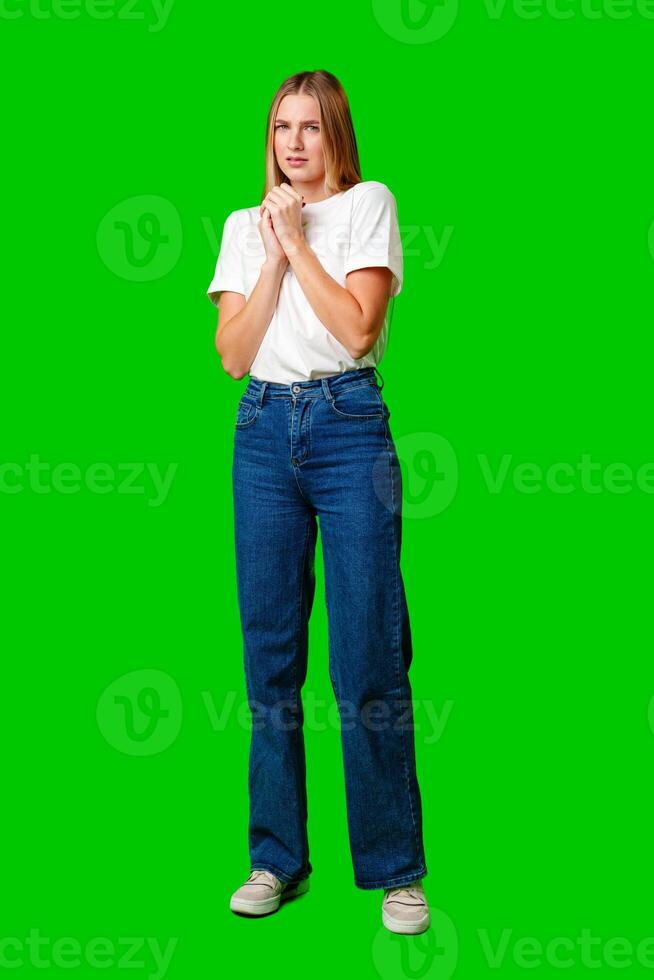 Young Woman With Pursed Lips Expressing Skepticism Against Green Screen Background photo