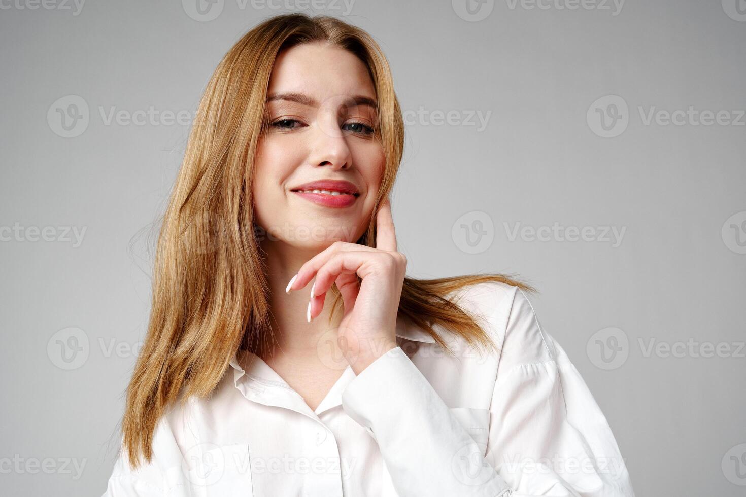 Joyful Young Blonde Woman Smiling against gray background photo