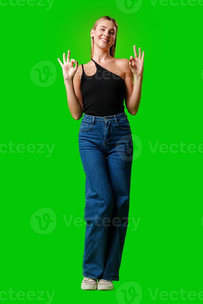 Young Woman Giving Thumbs Up Sign on Green Screen photo