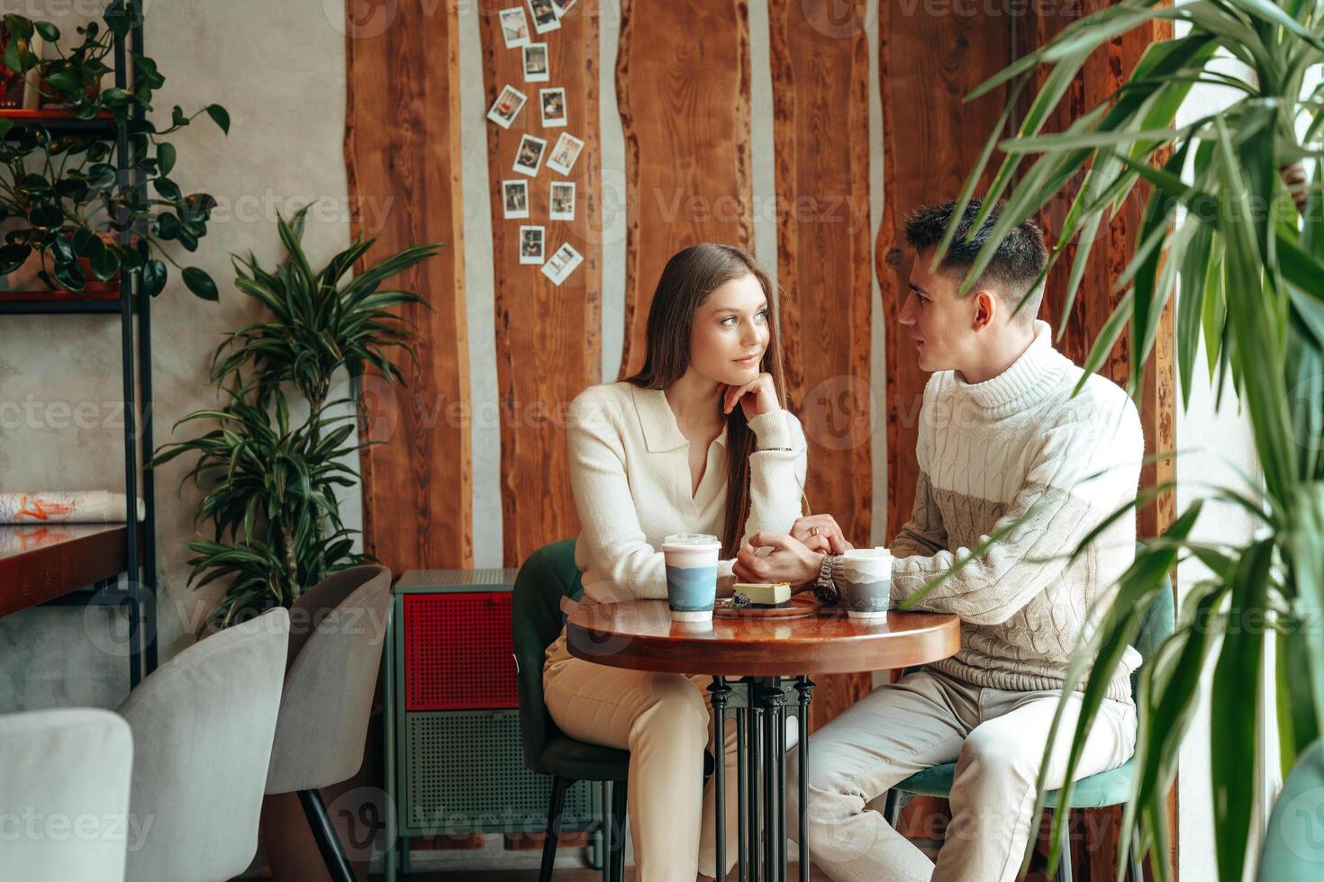 Young Couple Enjoying a Cozy Conversation at a Quaint Cafe During Daytime photo