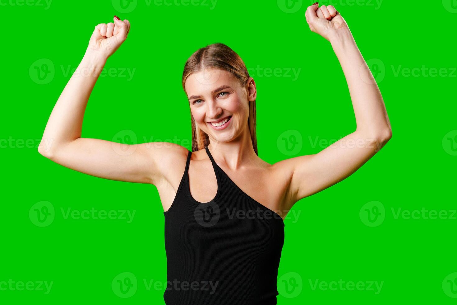 Happy Young Woman Raising Fists against green background photo