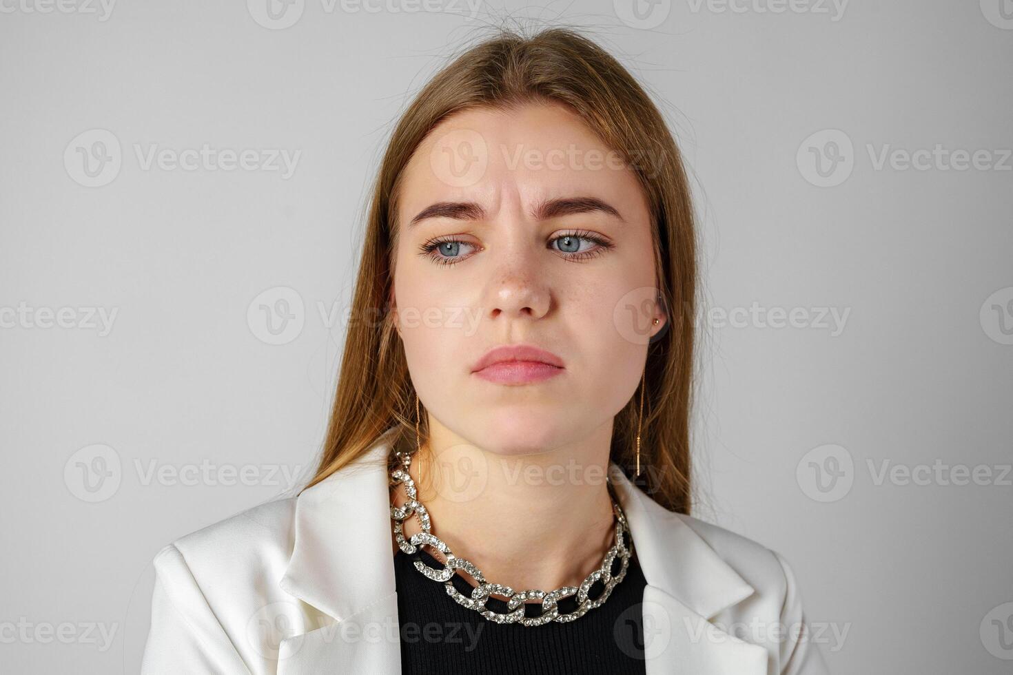 Young Woman Expressing Discontent against gray background photo