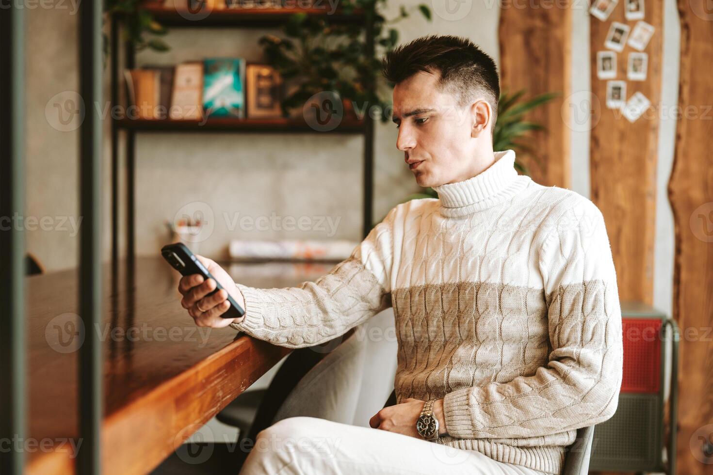 Man Sitting at Desk Using Cell Phone photo