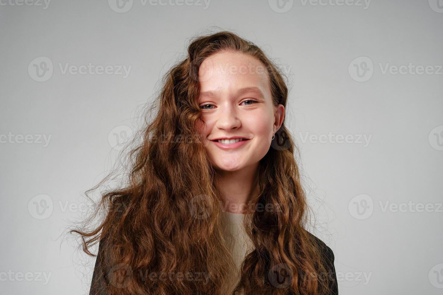 Woman With Long Hair and Blue Eyes on gray background photo