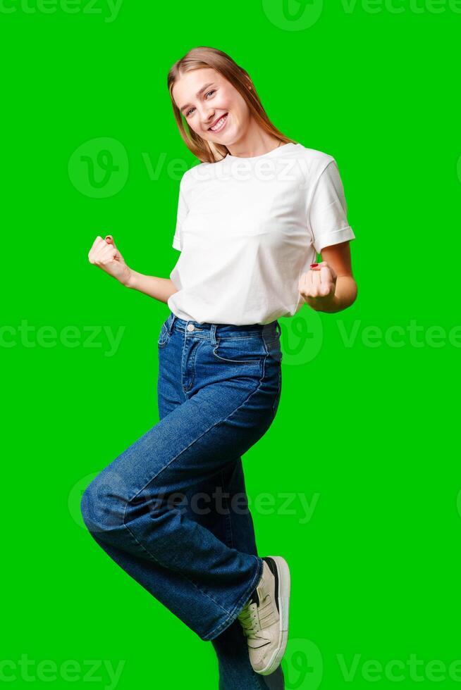 Happy Young Woman Raising Fists against green background photo
