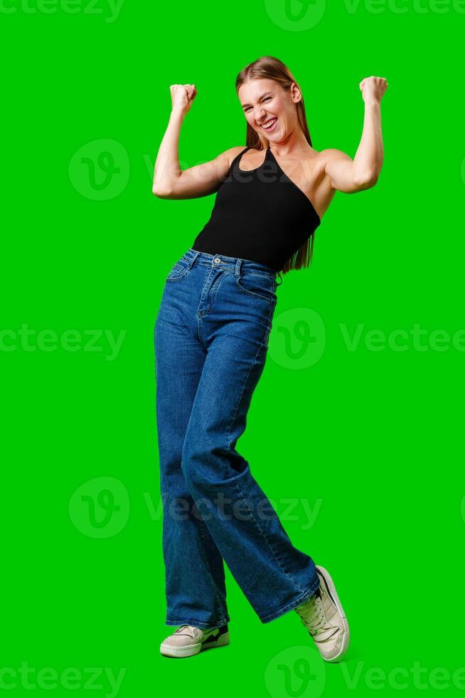 Happy Young Woman Raising Fists against green background photo