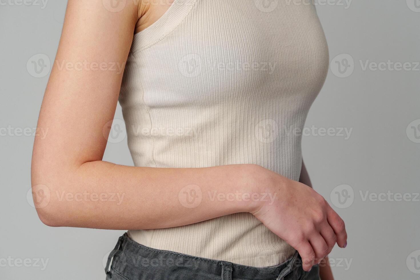 Female body in beige top on gray background photo