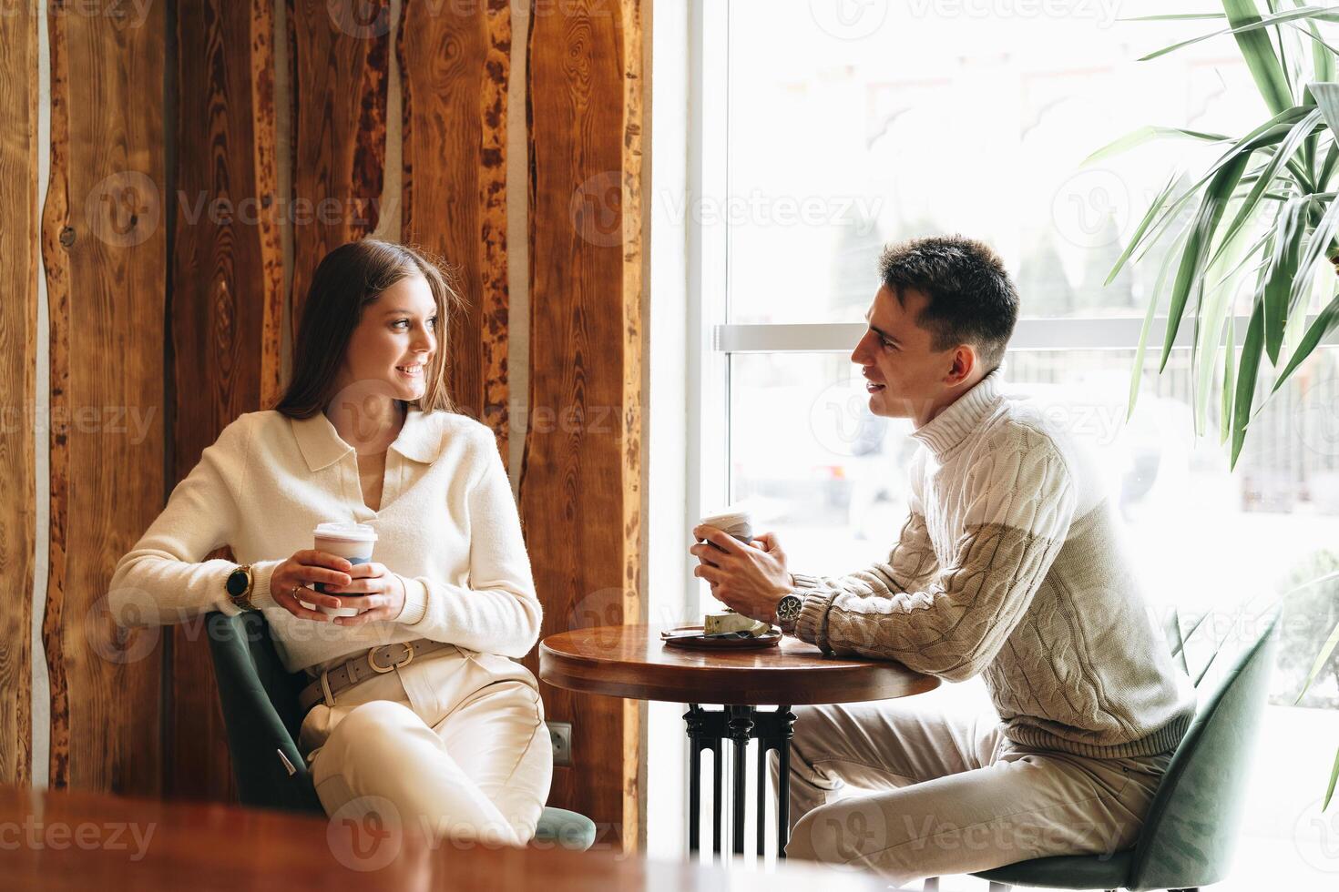 Two People Engaged in Casual Conversation at a Cozy Cafe During the Day photo