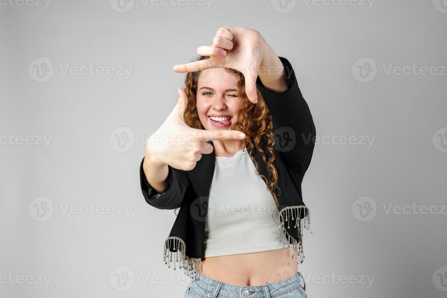 Woman Making Hand Gesture Picture Frame in Studio photo