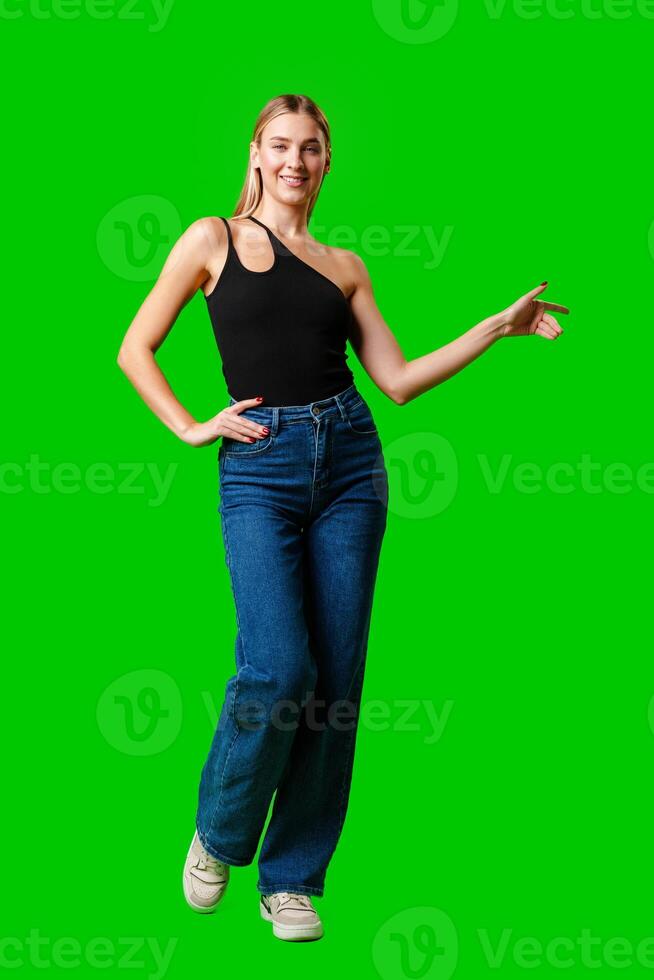 Young Woman Pointing at Something against green background photo