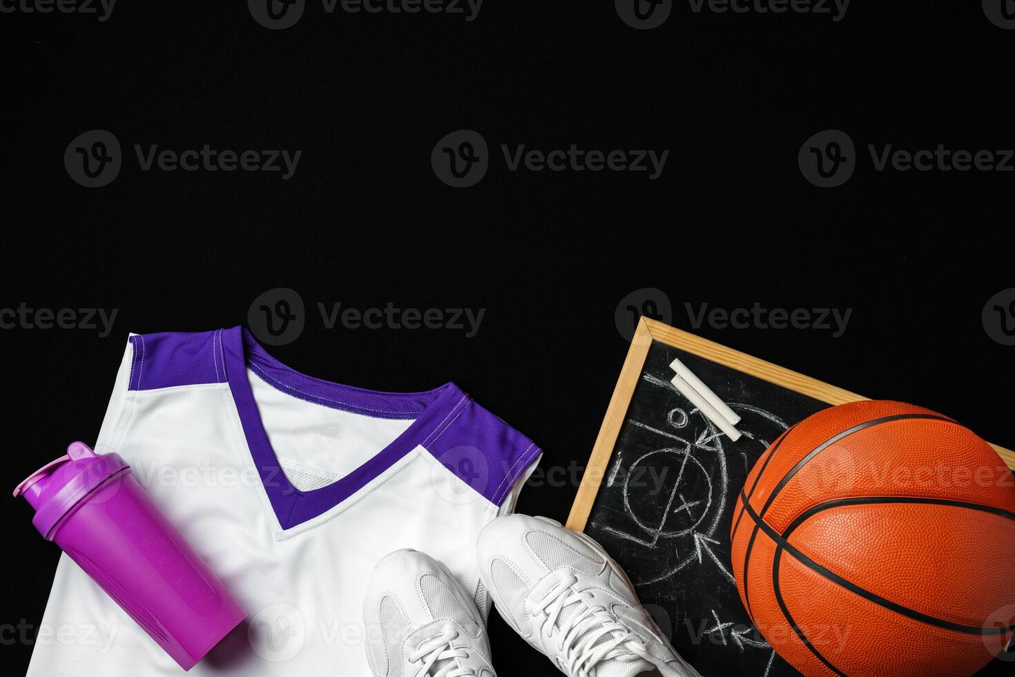 Basketball Gear Including Sneakers, Ball, and Play Strategy Board on Black Background photo