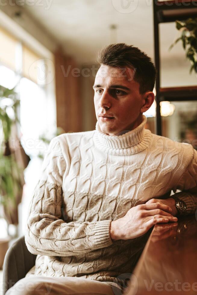Man Sitting at a Table With Arms Crossed photo