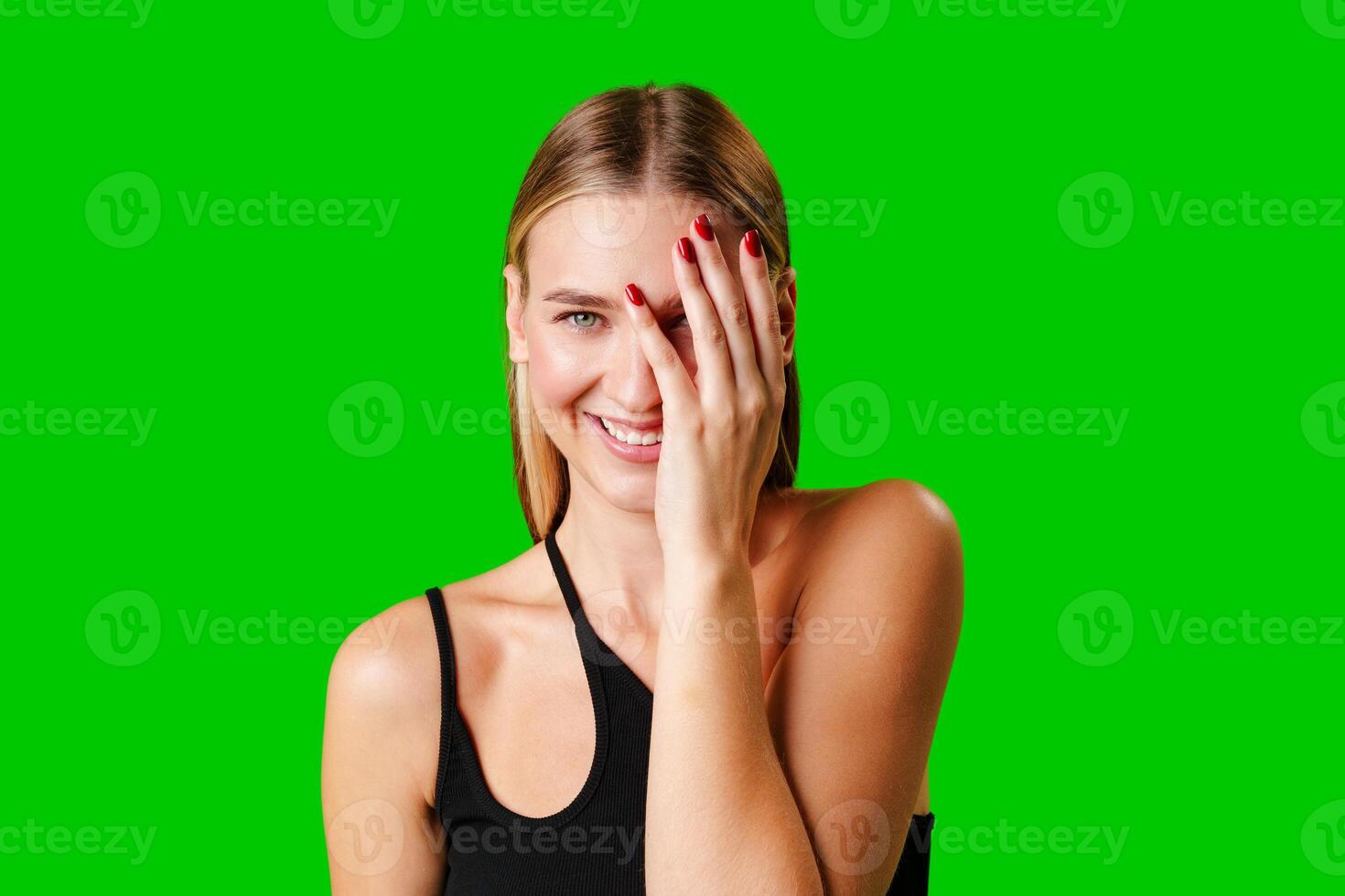 Smiling Young Woman in Casual Outfit Posing Against Green Background photo