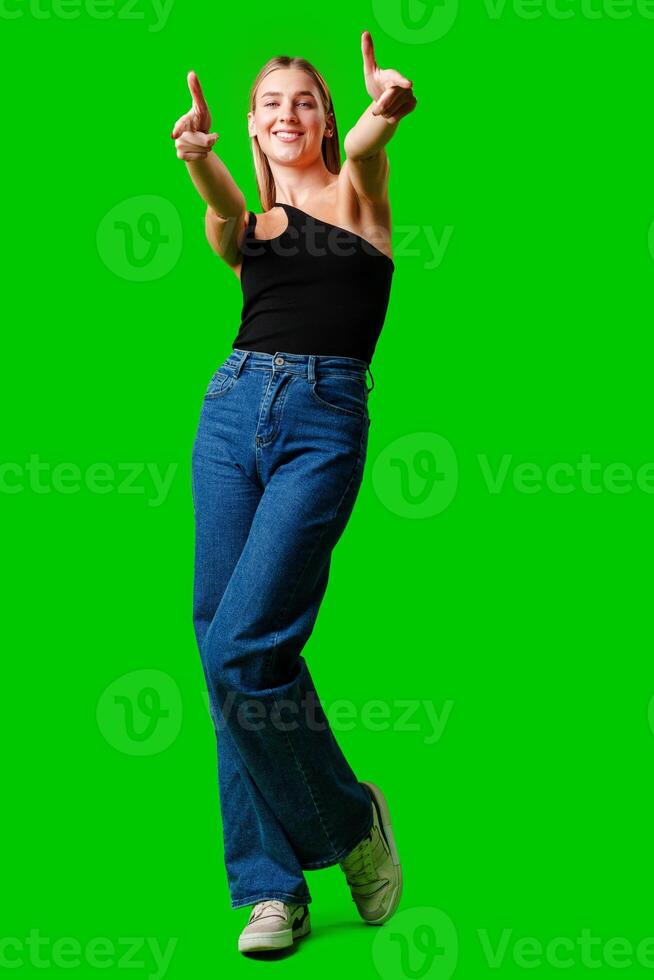 Young Woman Pointing at Something against green background photo
