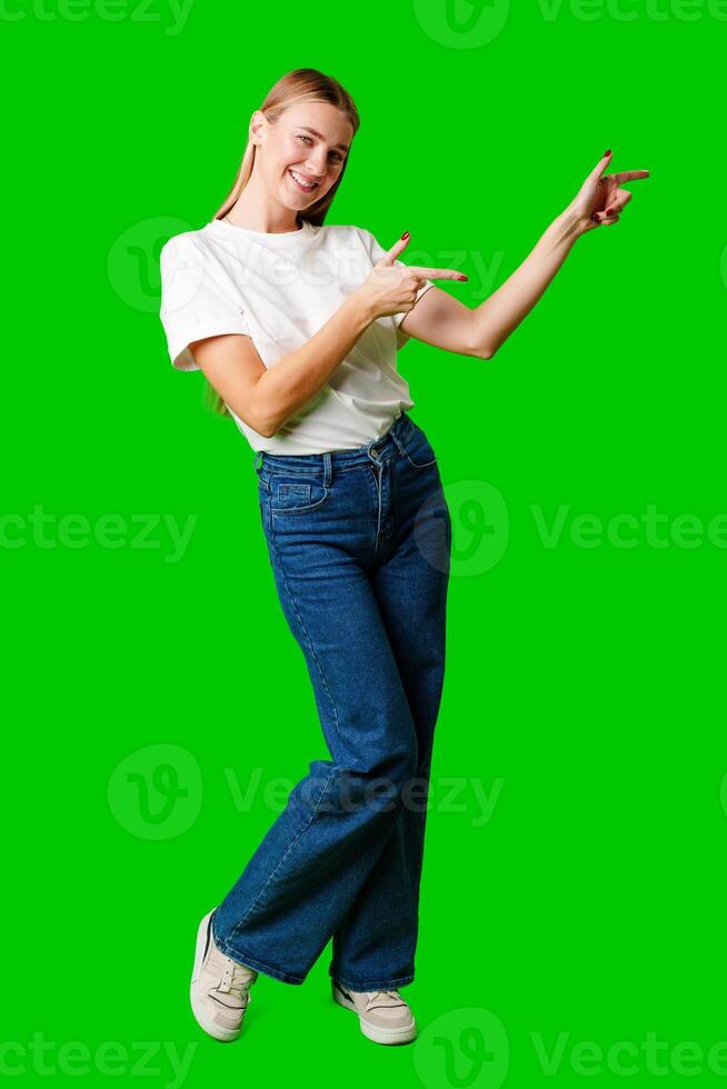 Young Woman Pointing at Something against green background photo