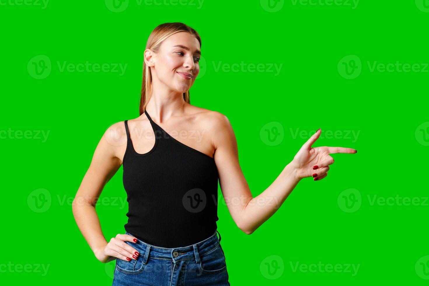 Young Woman Pointing at Something against green background photo