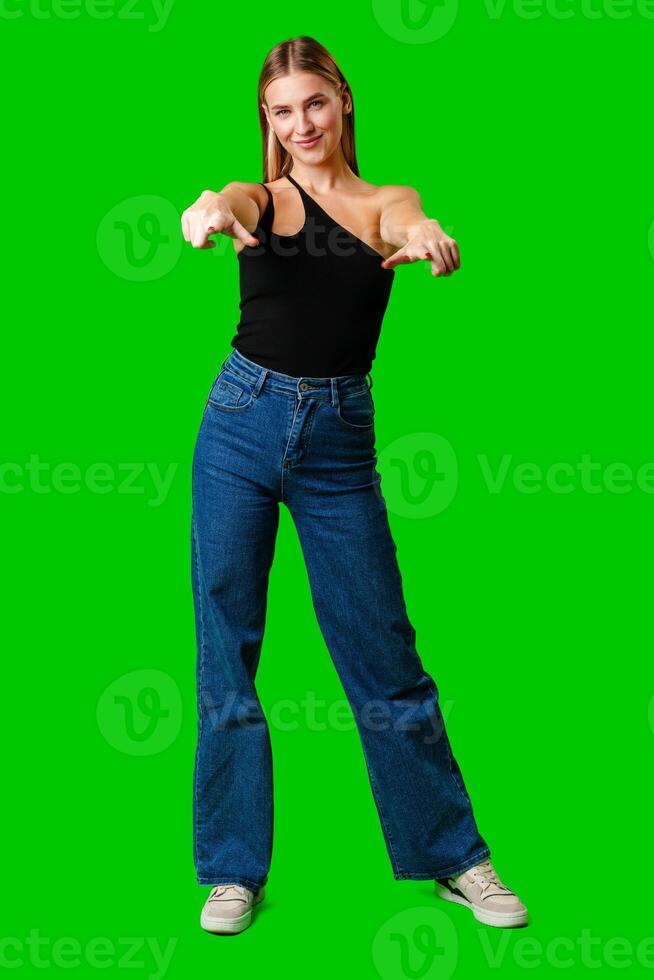 Young Woman Pointing at Something against green background photo