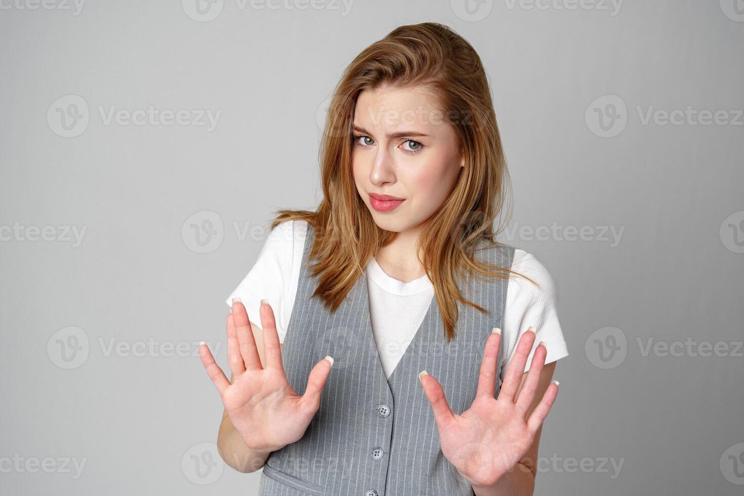 Woman in Vest Holding Hands Up in Studio photo