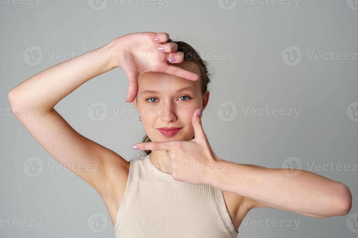 Woman Posing for Picture With Hands on Head on gray background photo