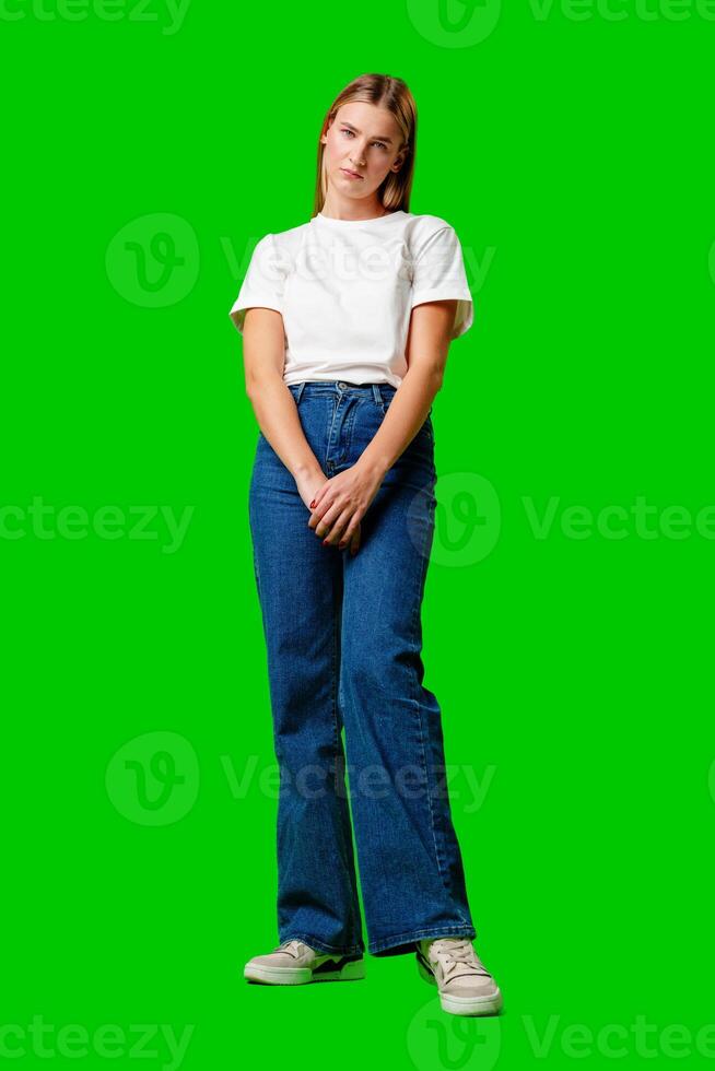 Young Woman With Pursed Lips Expressing Skepticism Against Green Screen Background photo