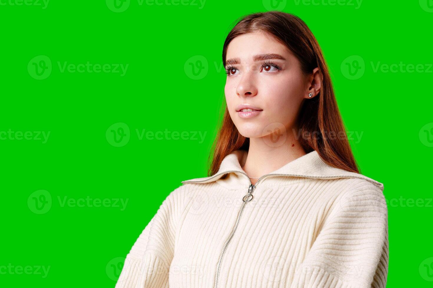Young Woman in Casual Attire Posing Against Vivid Green Background in Studio Setting photo