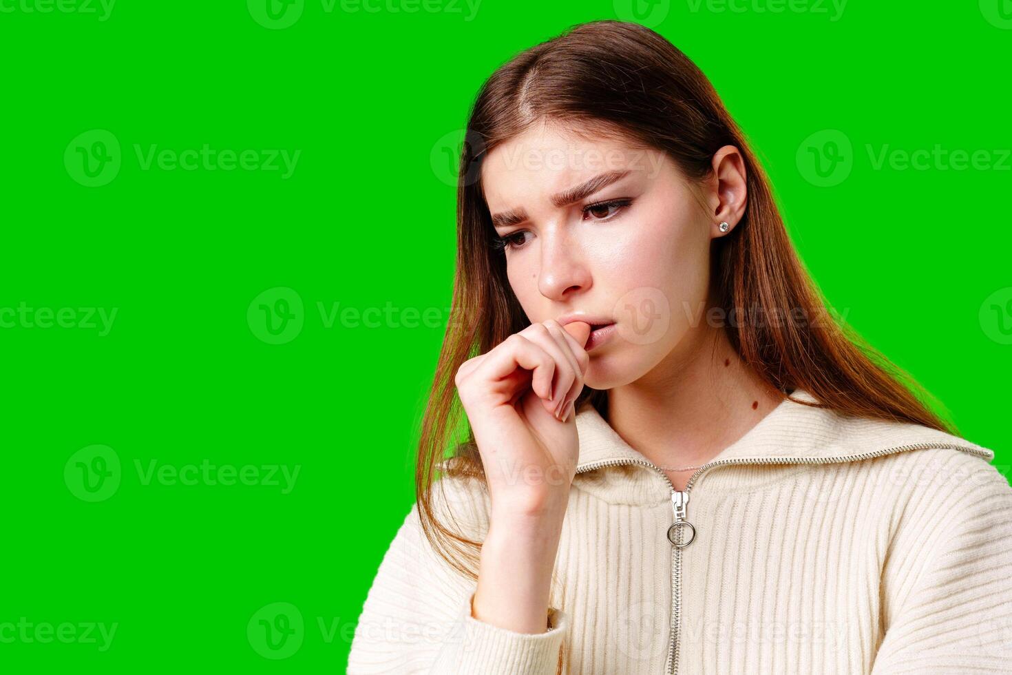 Young Woman Contemplating Deeply Against a Vibrant Green Background photo