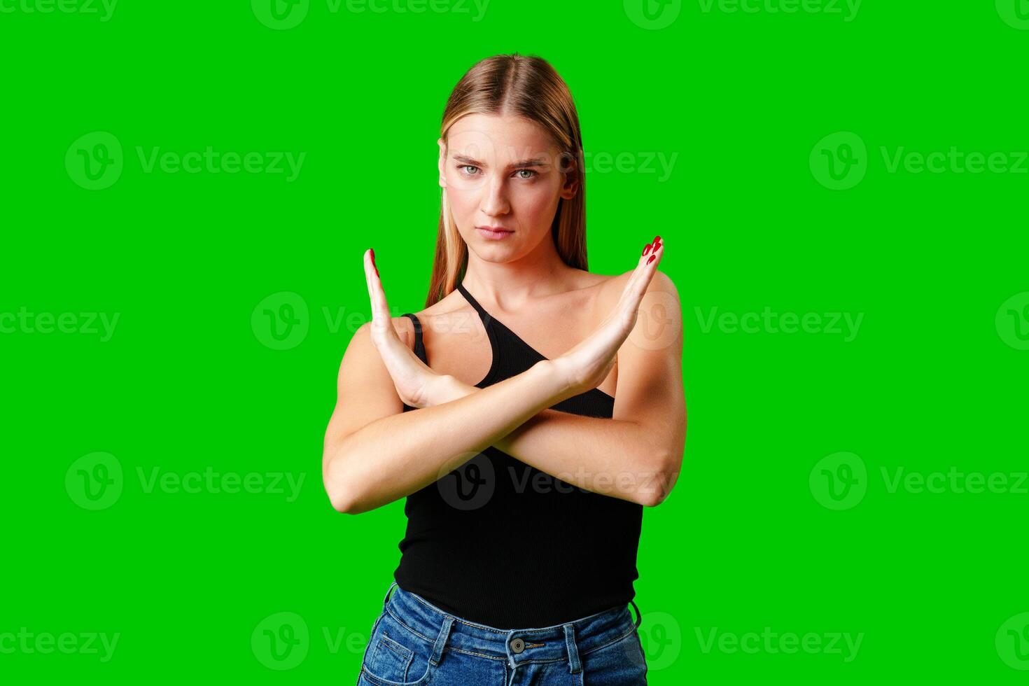 Young Woman Making Stop Sign Gesture on green background photo