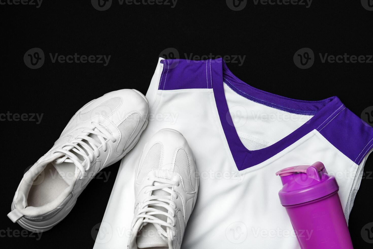 White Sneakers, Purple Accented Tank Top, and Shaker Bottle on a Black Background photo