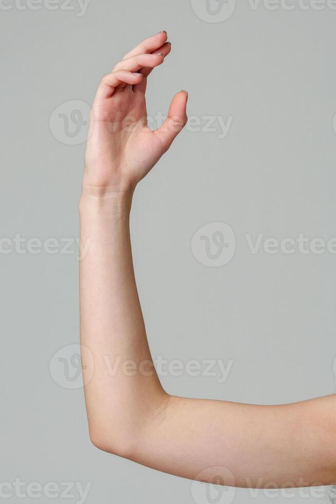 Female hand sign against gray background in studio photo