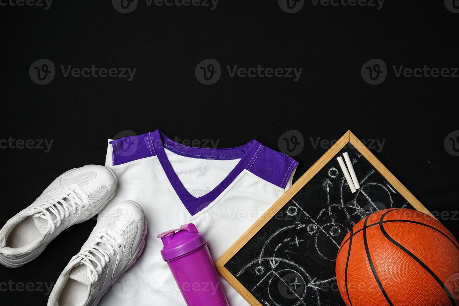 Basketball Gear Including Sneakers, Ball, and Play Strategy Board on Black Background photo