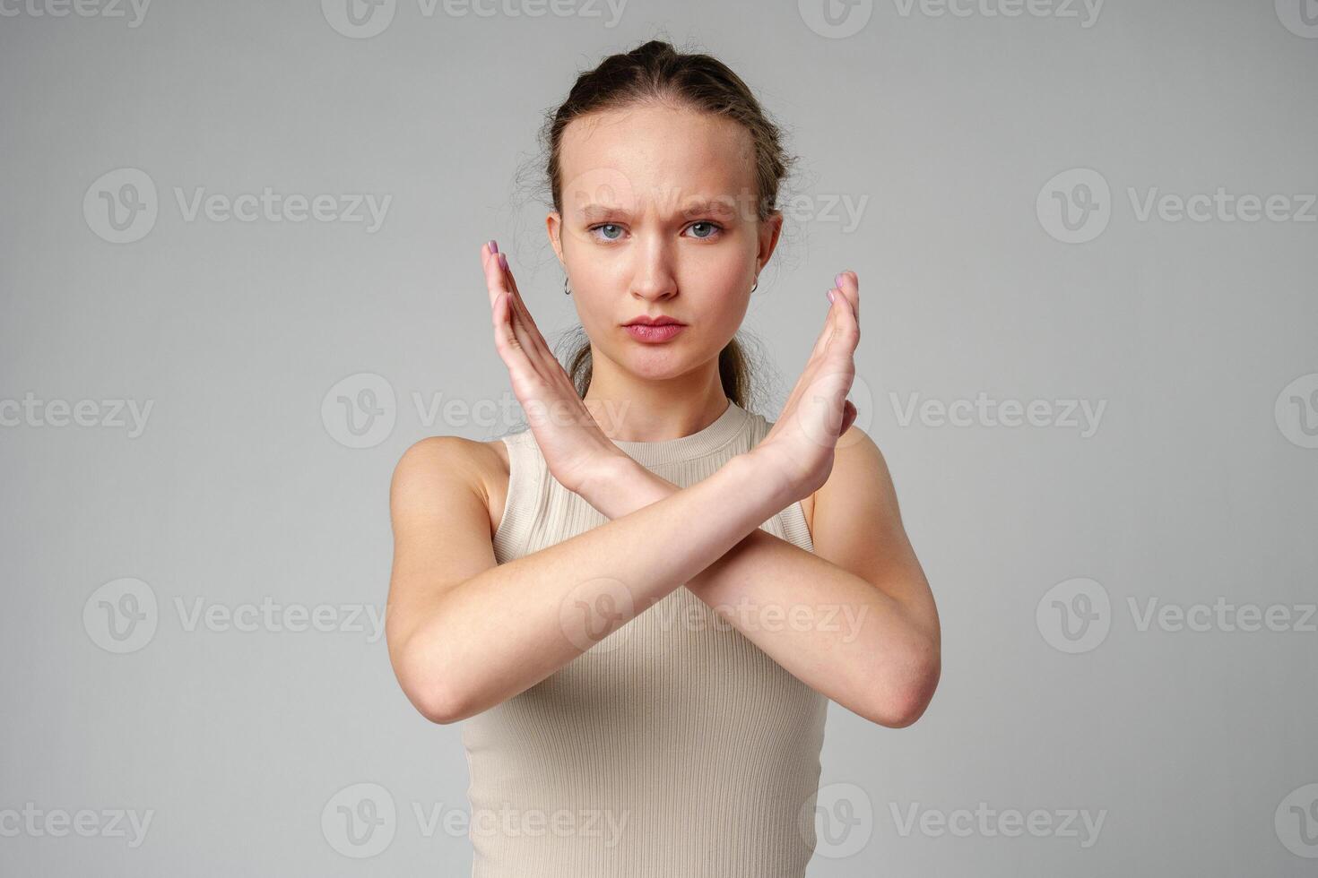 Young Woman Making Stop Sign With Hands on gray background photo