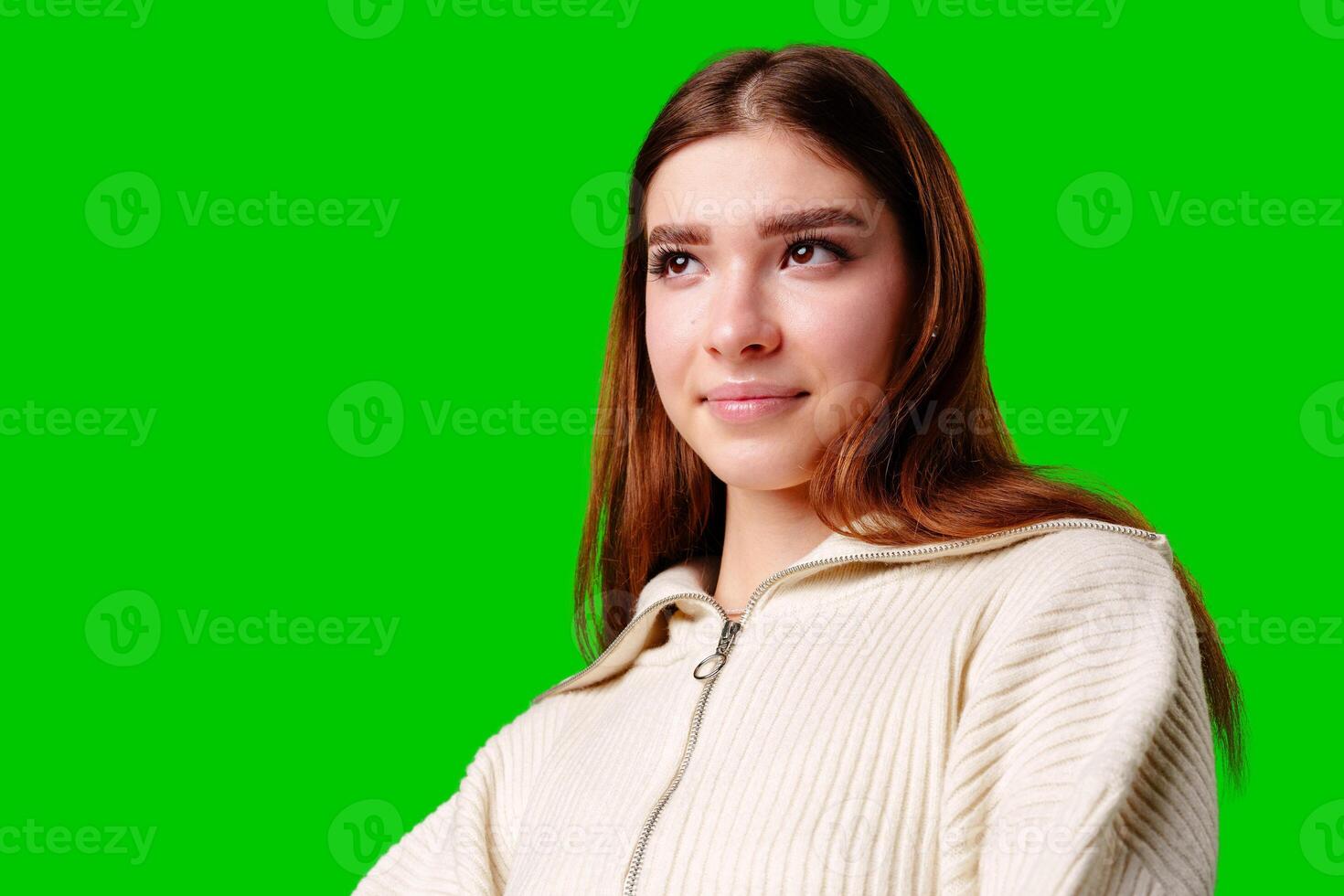 Young Woman Posing in Stylish Crop Hoodie and Pleated Skirt Against Green Screen photo