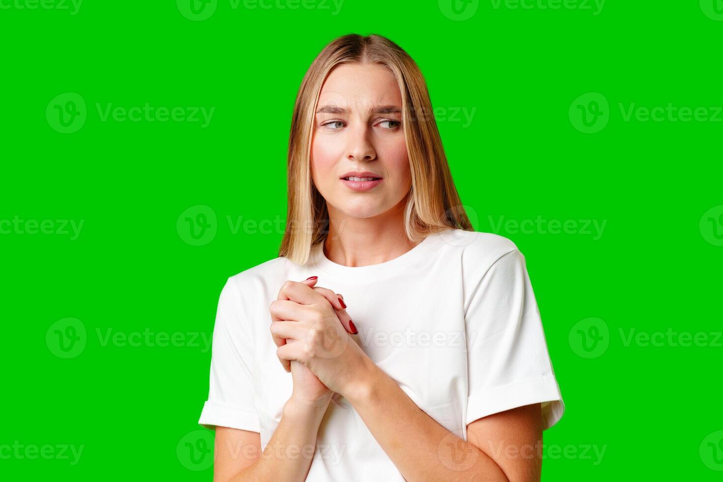 Young Woman With Pursed Lips Expressing Skepticism Against Green Screen Background photo