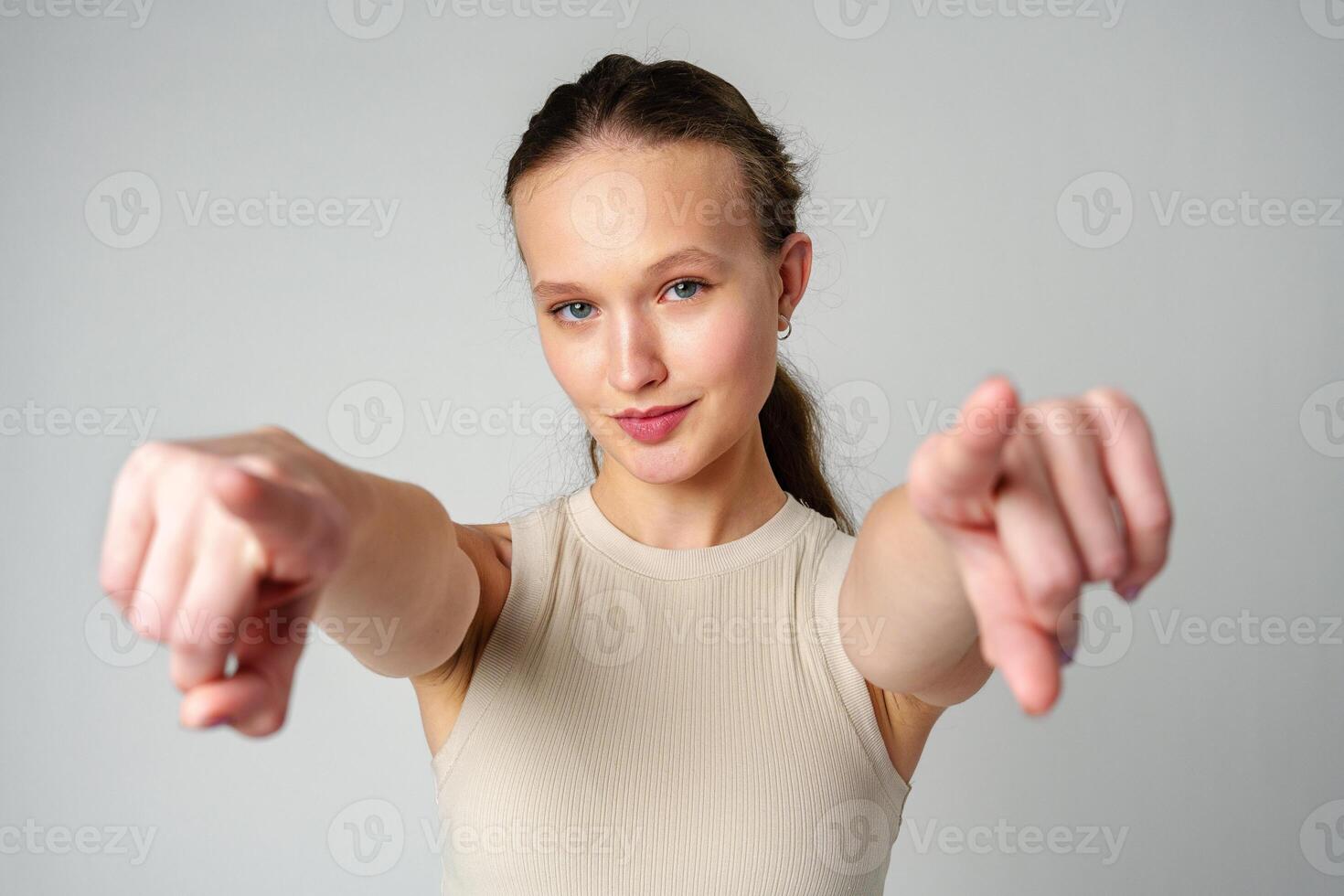 Young Woman in Tank Top Pointing at Camera photo