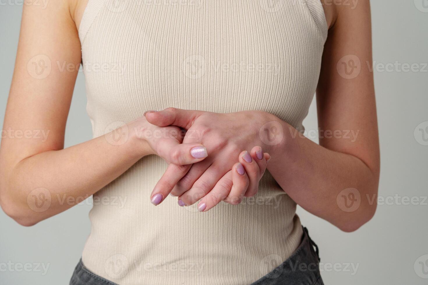 Female body in beige top on gray background photo