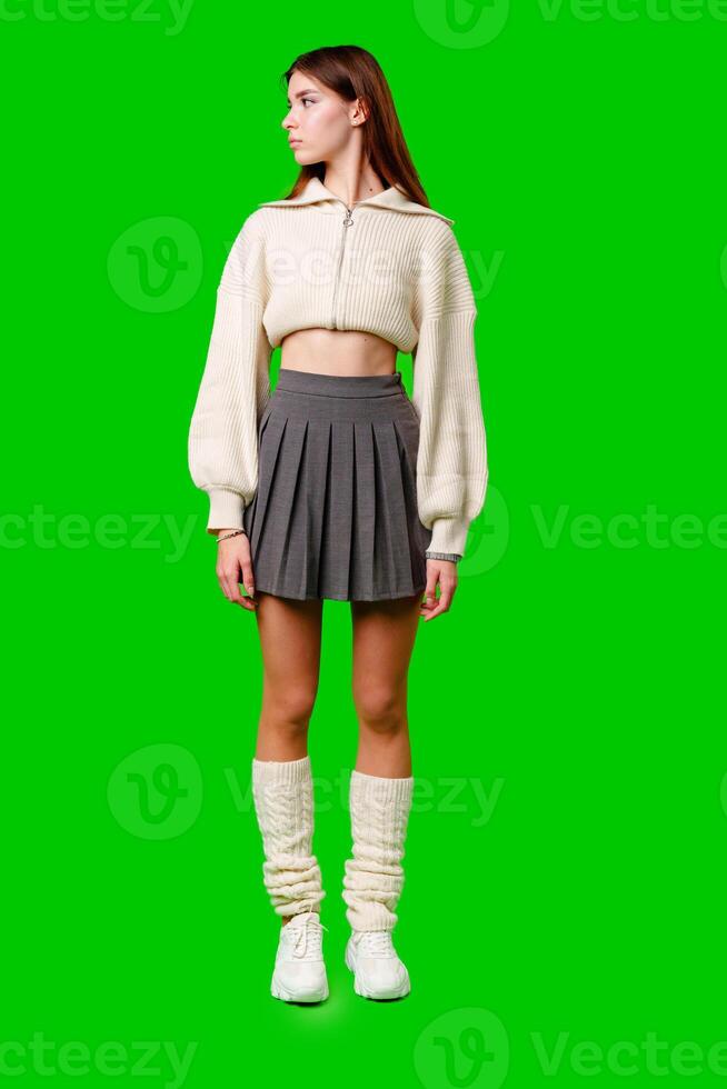 Young Woman in Trendy Attire Posing Against a Green Background During Daytime photo