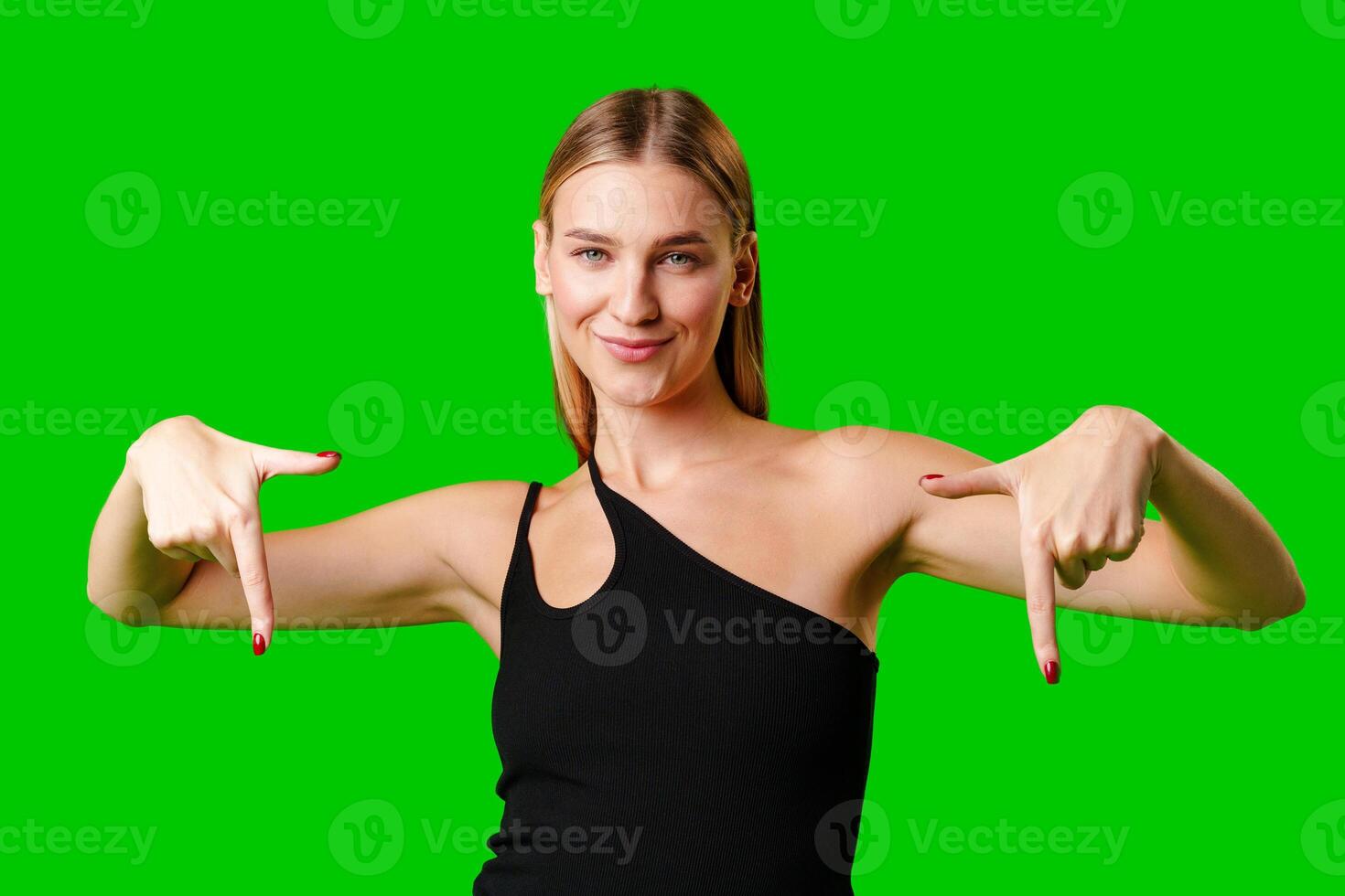 Young Woman Pointing at Something against green background photo
