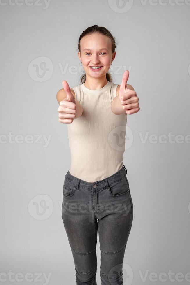Young Girl Giving Thumbs Up Sign in studio photo