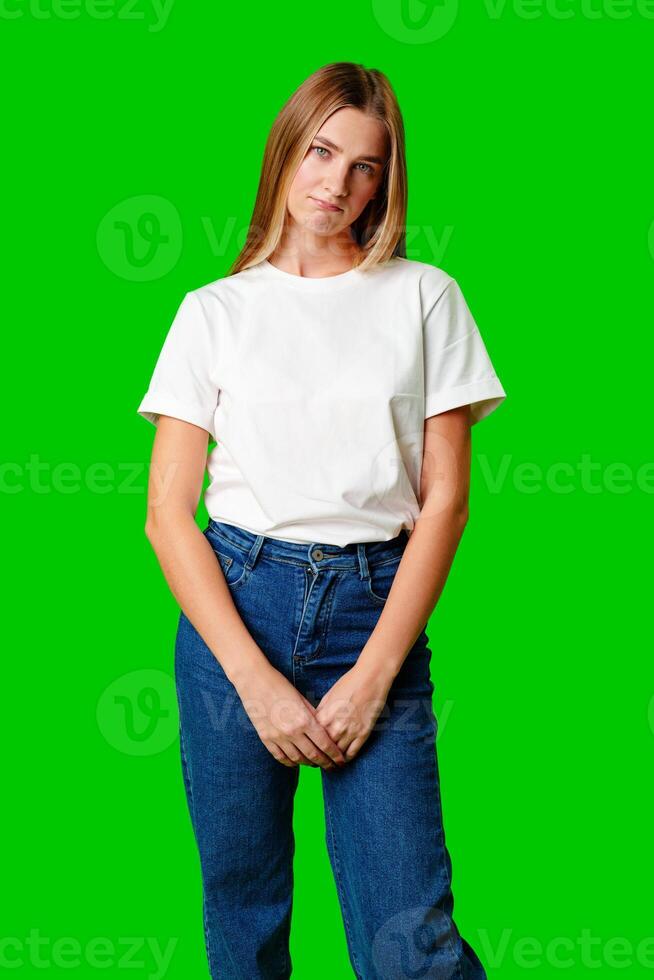Young Woman With Pursed Lips Expressing Skepticism Against Green Screen Background photo