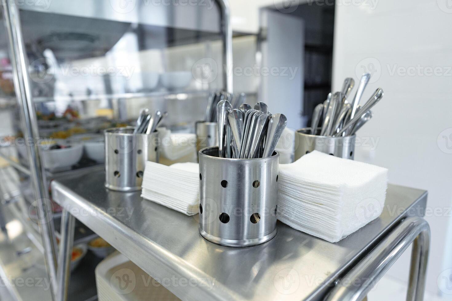 Stainless Steel Utensils Organized in Containers on a Service Cart in a Commercial Kitchen photo