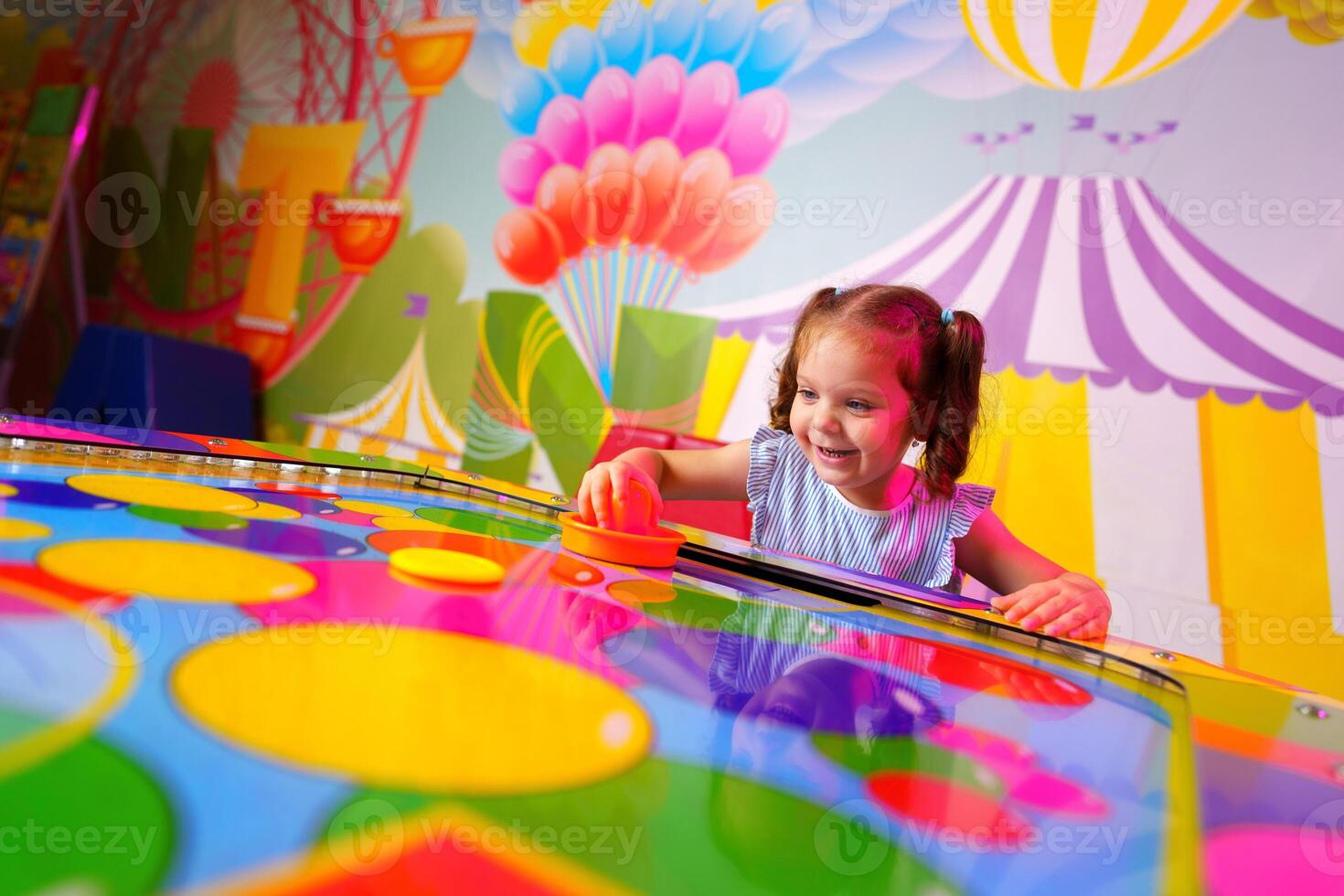 Young Girl Engaging in Colorful Board Game Fun at a Vibrant Playroom photo