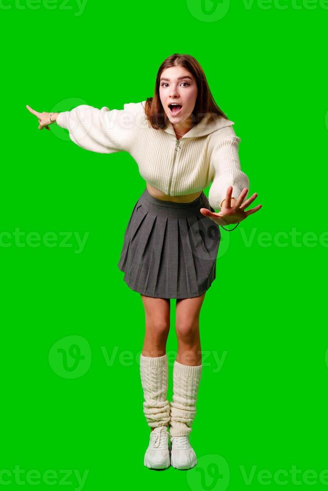 Young Woman Gesturing Excitement in Casual Attire Against Green Screen Backdrop photo