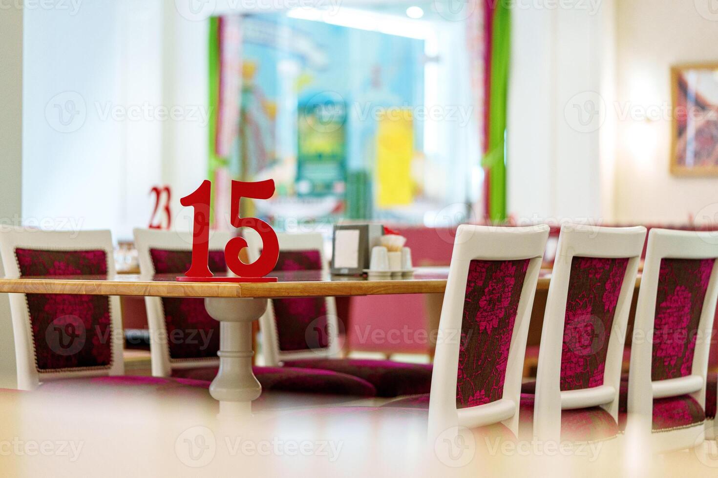 Vibrant Restaurant Interior With Red Number 15 on Table and Colorful Artwork in Background photo