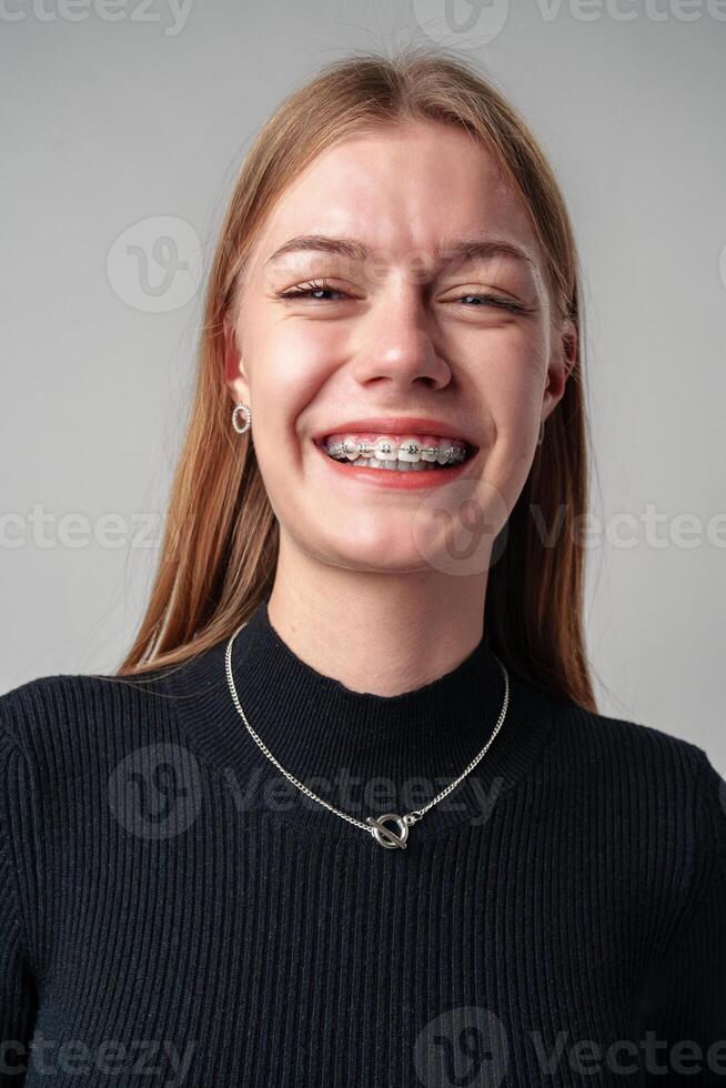 Smiling Woman in Black Top against gray background photo