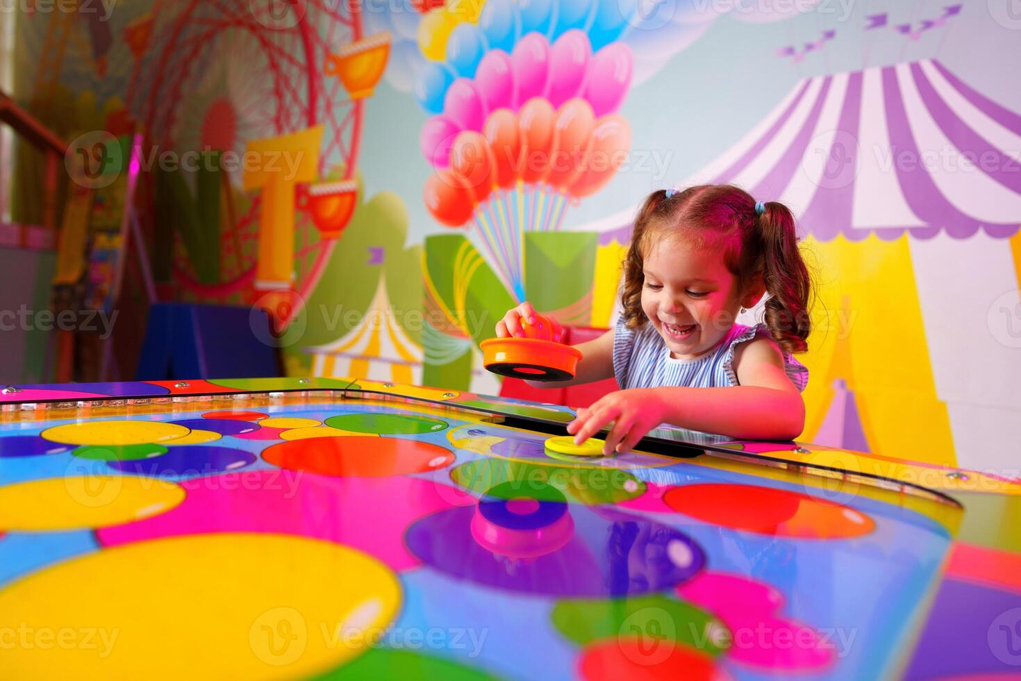 Young Girl Engaging in Colorful Board Game Fun at a Vibrant Playroom photo