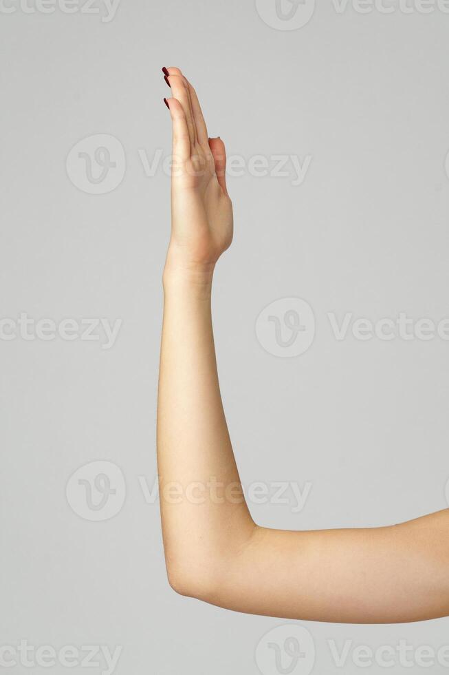 Young woman hand gesture on gray background photo